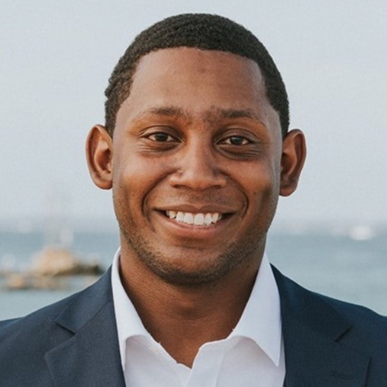 Portrait of Court Bluford, product and engineering lead for Shoes & Booze, in a navy blazer outdoors.